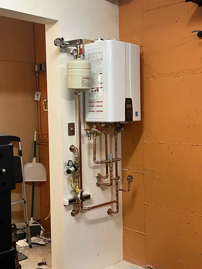 Plumbing technician inspecting water heater connections in Quartz Hill